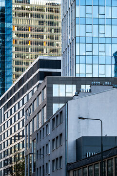 Stacked office buildings in Warsaw, Poland, reveal an urban business district as corporate architecture layers facade patterns from street level