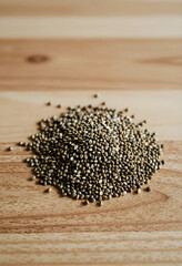Fototapeta premium Pile of organic hemp seeds on a light wooden surface, healthy eating and superfood for nutrition and wellness, the natural plant based ingredient is suitable for various diets and culinary uses