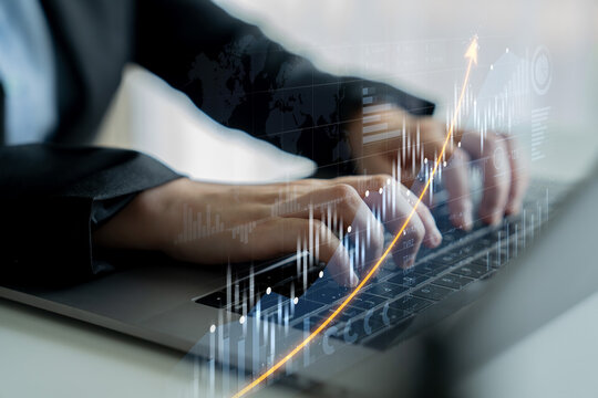 A close-up of professional hands typing on a laptop, overlaying visual data charts and graphs, symbolizing financial growth and modern business analysis. Scalp