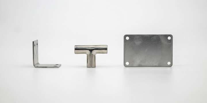Metal l bracket, t shaped pipe connector, and rectangular plate on white