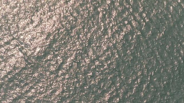 Drone aerial looking down at windy weather on Great Lakes Lake Erie outside Cleveland, Ohio as natural sunny weather with sun and wind hitting waves on water surface in sea and Ocean landscape ocean