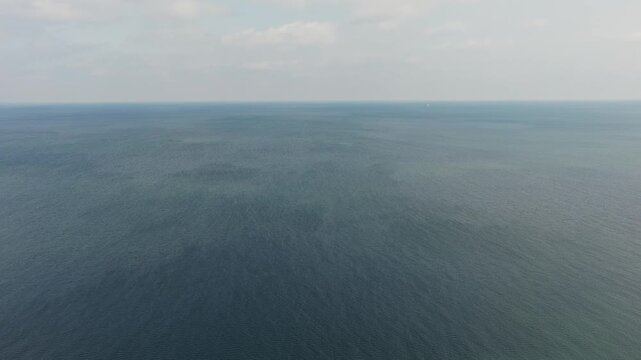 Drone aerial looking down at windy weather on Great Lakes Lake Erie outside Cleveland, Ohio as natural sunny weather with sun and wind hitting waves on water surface in sea and Ocean landscape ocean