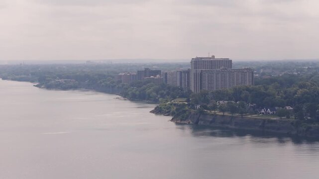 Drone aerial of condominium complex residential building and buildings along shoreline and Lake Erie coast outside Cleveland, OH by waterscape and waterfront of Ohio northern shore apartment structure