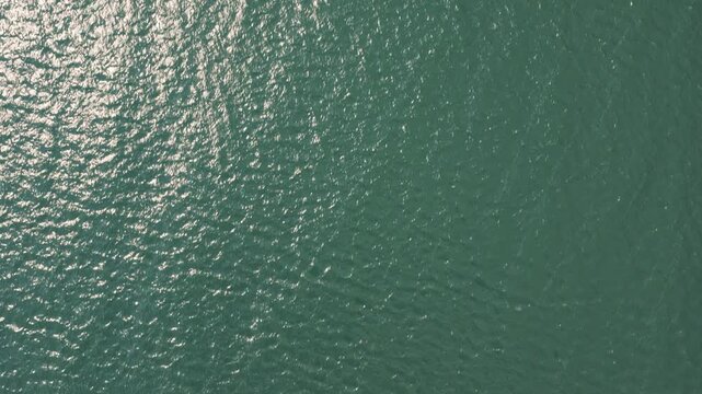 Drone aerial looking down at windy weather on Great Lakes Lake Erie outside Cleveland, Ohio as natural sunny weather with sun and wind hitting waves on water surface in sea and Ocean landscape ocean