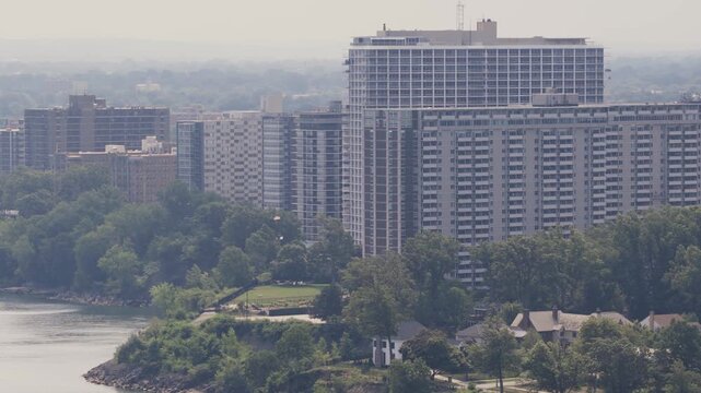 Drone aerial of condominium complex residential building and buildings along shoreline and Lake Erie coast outside Cleveland, OH by waterscape and waterfront of Ohio northern shore apartment structure
