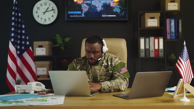Black American intelligence officer coordinates military mission on laptops