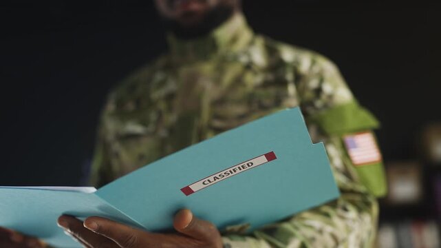 Black U.S. service member checks classified folder, reads confidential report
