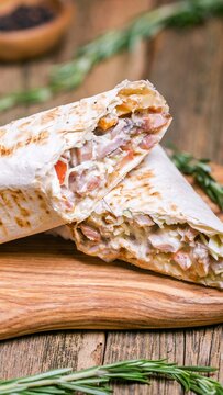 Close up view of fresh pita bread filled with creamy seasoned ingredients, perfect for a light meal or gathering snack, rustic wooden surface backdrop