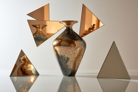 Metallic vase with mirror triangles. Artistic decor for luxury design.