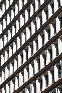 Diagonal frames project across a modern architecture facade, where windows, shadows and repetition create a bold pattern through layered geometry.