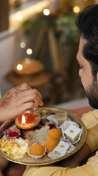 Woman applying tilak during a traditional Indian festival ritual