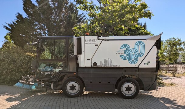 Cami&oacute;n barredor de calles con cepillos giratorios del Servicio de Limpieza del Ayuntamiento de Madrid, Espa&ntilde;a, aparcado en la acera de un parque p&uacute;blico, 3 de junio de 2026
