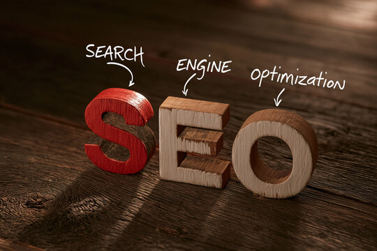 3D wooden letters "SEO" with handwritten "Search Engine Optimization" on a rustic wooden table. Perfect for digital marketing and online business concepts.