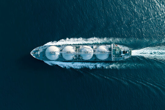 A zenithal perspective of a sizable LNG tanker, equipped with spherical gas compartments, navigates across the vast sea. Ideal for subjects encompassing maritime commerce, energy conveyance, and globa