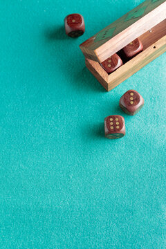 Wooden dice on a green cloth.