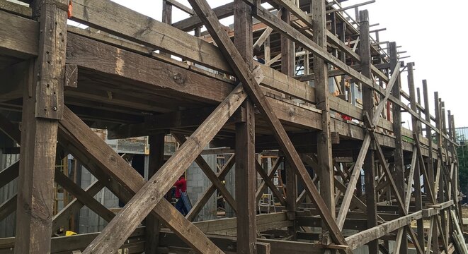 Temporary scaffolding made of wooden planks and supports for a building construction project.Concept of construction safety and temporary structures.