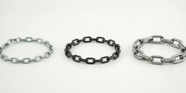 Three circular metal chains of different sizes and finishes on a white background
