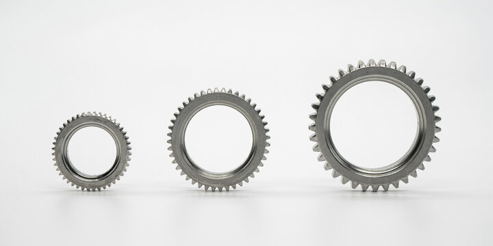 Three circular metal gears of varying sizes aligned on a plain white background