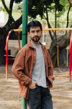 Young man with glasses using a mobile phone in a park