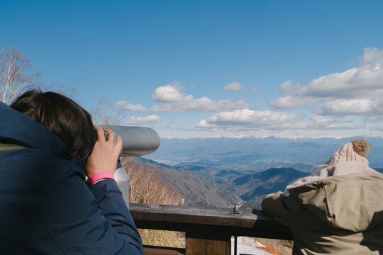 Father and daughter at mountain viewpoint.