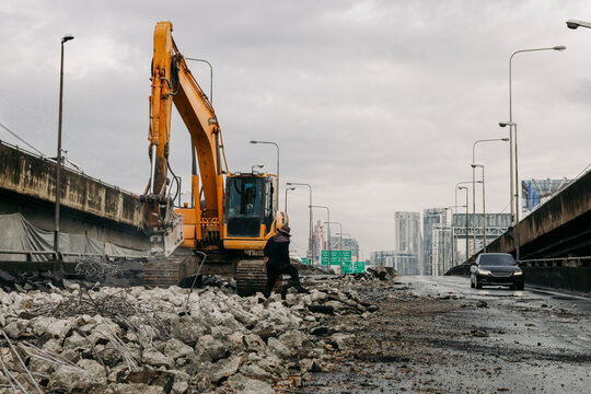 Construction workers working on an expressway demolition on cloudy day