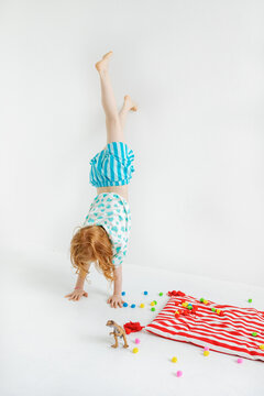Child does handstand on a white background