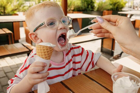 A child enjoys ice cream on a warm day in the park.