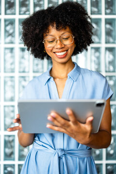 Woman Smiles While Using Tablet in Modern Space