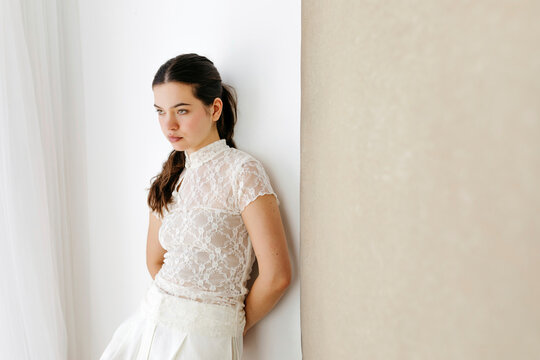 Woman wearing white lace top looking away