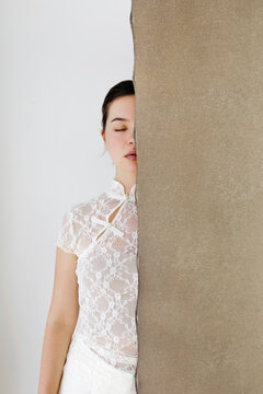 Woman hidden face behind textured panel