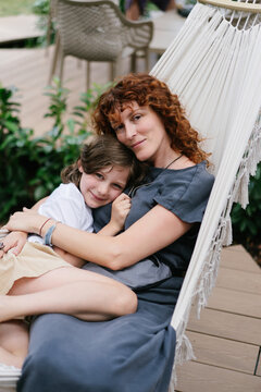 Mother and daughter embracing on hammock