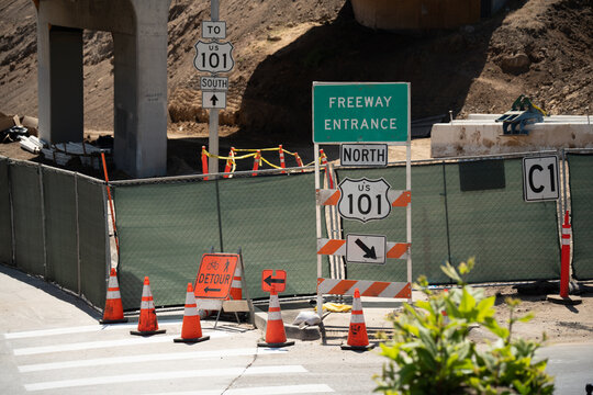 Highway construction zone with detour signs and traffic cones on US 101