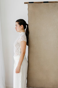 Woman in white lace top posing in profile