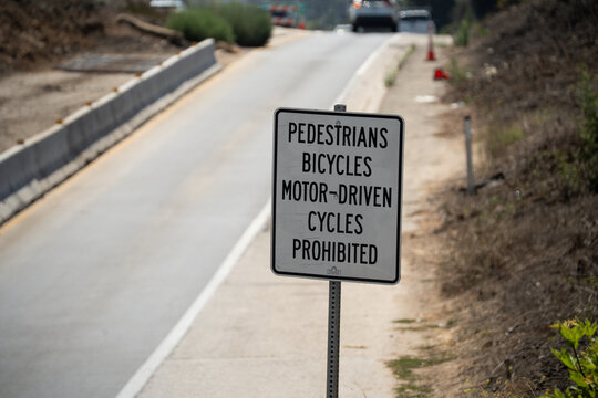Road sign prohibiting pedestrians, bicycles, and motor-driven cycles on a paved path