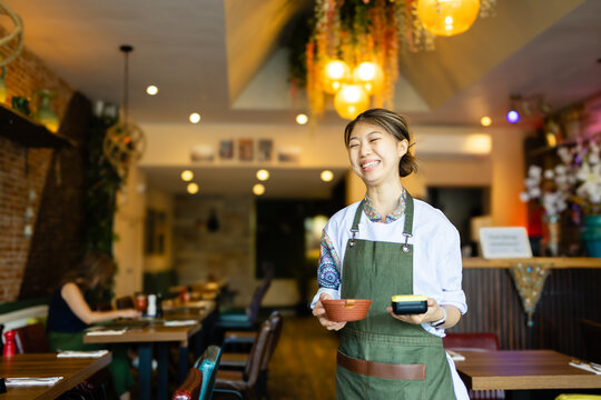 Waitress smiling while carrying card reader
