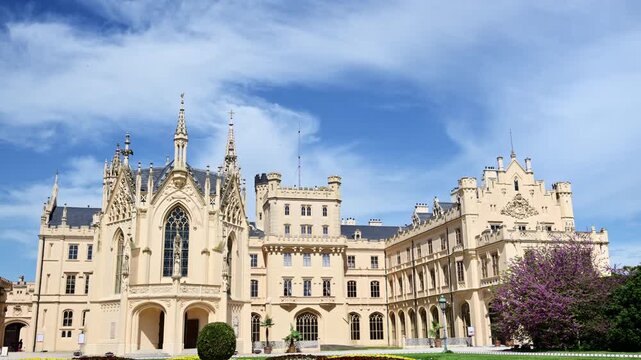 Lednice Castle and its chapel wing beside a purple blossoming tree, Czech Republic