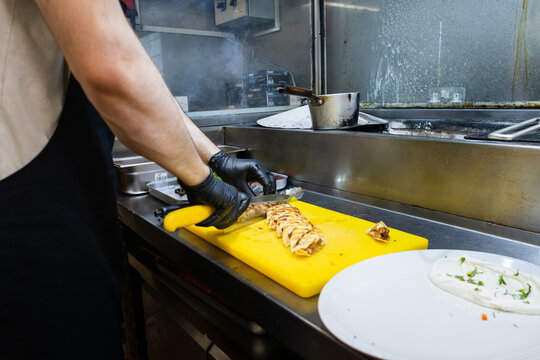 Chef slicing a Beyti kebab roll