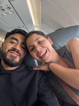 Happy couple smiling inside airplane