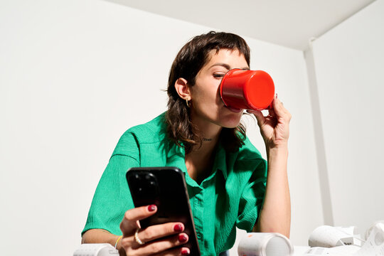 Brunette With Coffee looking at mobile phone