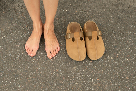Female feet and brown clogs shoes