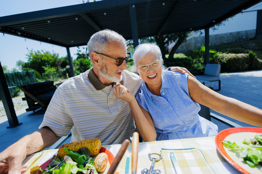 Senior couple enjoying meal outdoors laughing together