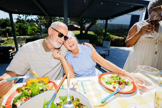 Senior couple enjoying meal at outdoor social gathering