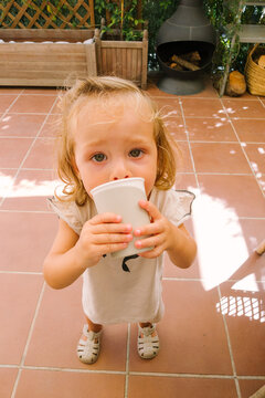 Toddler drinks water outdoors