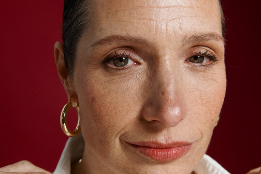 Woman With Short Hair and Hoop Earrings Looks at the Camera