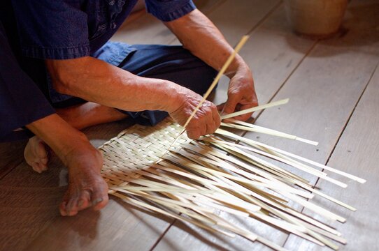 Close-Up of Elderly Artisan's Hands Weaving Bamboo Fan