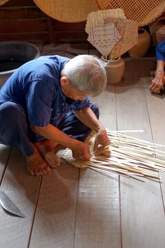 Elderly Man Weaves Bamboo Fan, Full Body, Rural Thailand