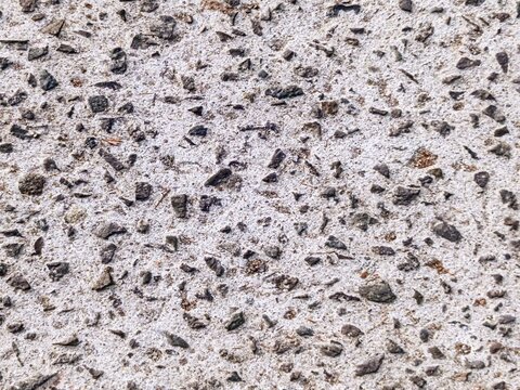Exposed aggregate concrete texture background with dark crushed stones