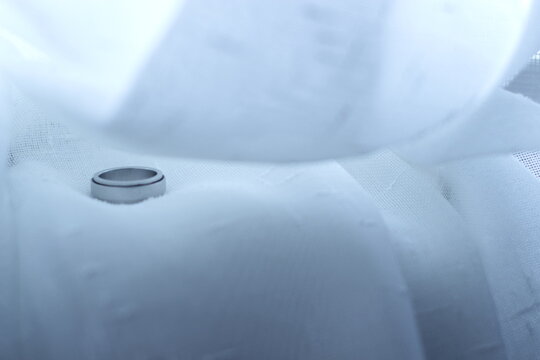 Wedding Ring on White Fabric