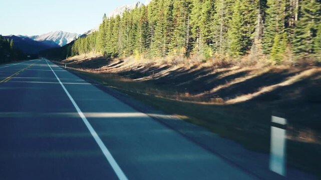Point-of-view driving shot on a mountain highway through autumn landscape