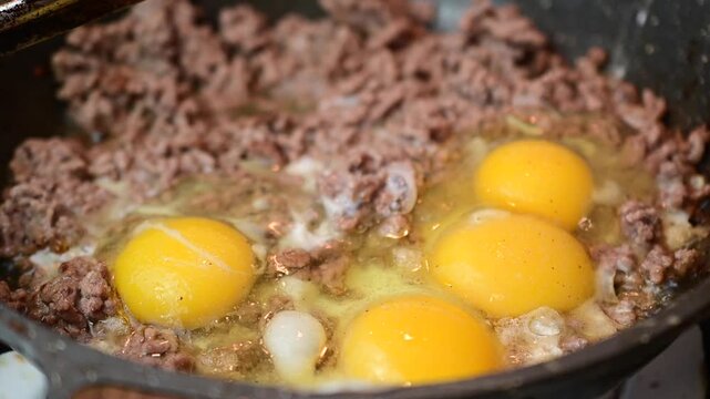 Beef with eggs on frying pan close up cooking frying pan authentic real life close up, bokeh background b roll video